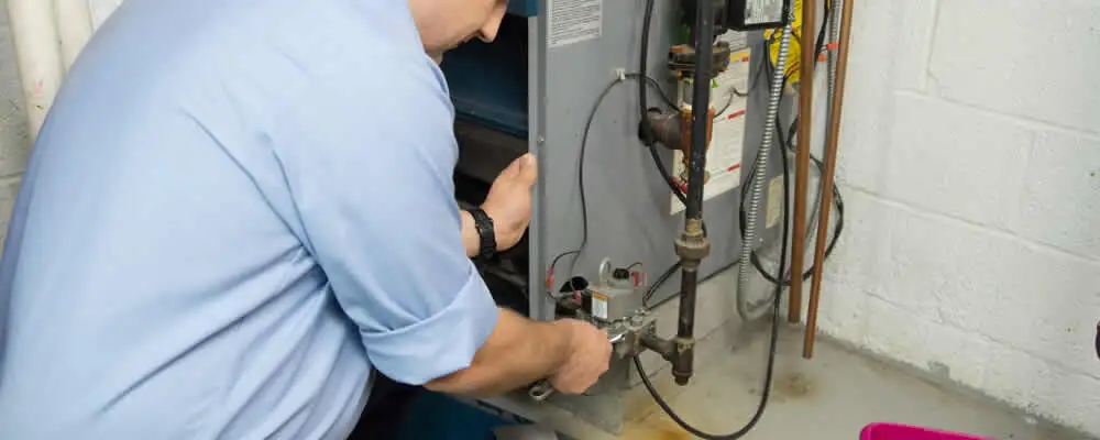 Furnace repair technician inspecting and servicing a home heating system in Los Angeles, CA