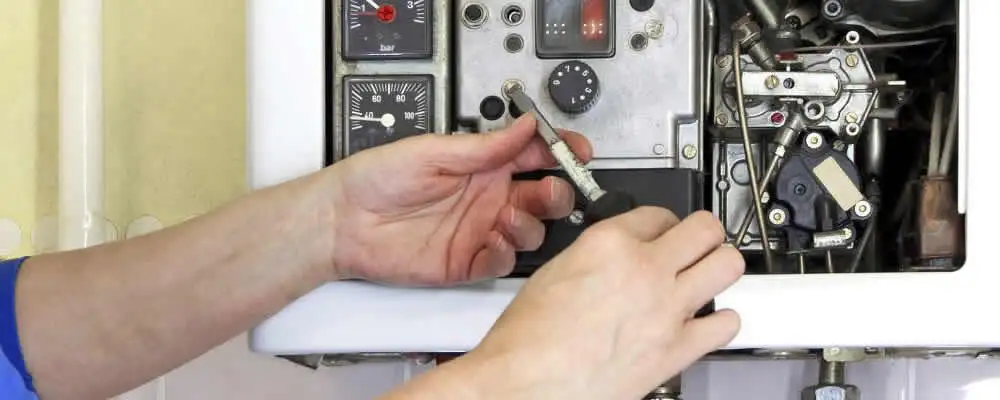 Heating repair technician adjusting boiler controls and components in Los Angeles, CA