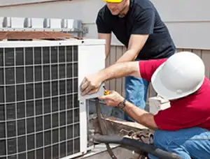 HVAC technicians repairing an outdoor AC unit on a rooftop in Los Angeles, CA