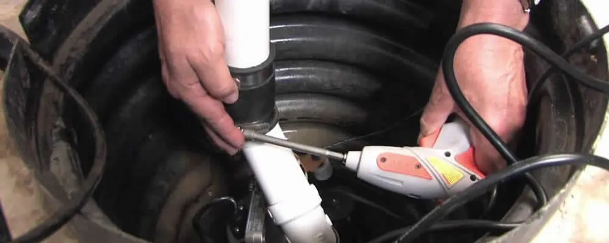 Sump pump installation technician connecting PVC discharge piping in Los Angeles, CA