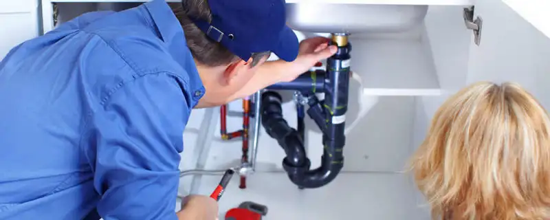 Plumber repairing under-sink drain pipes and fittings in Los Angeles, CA